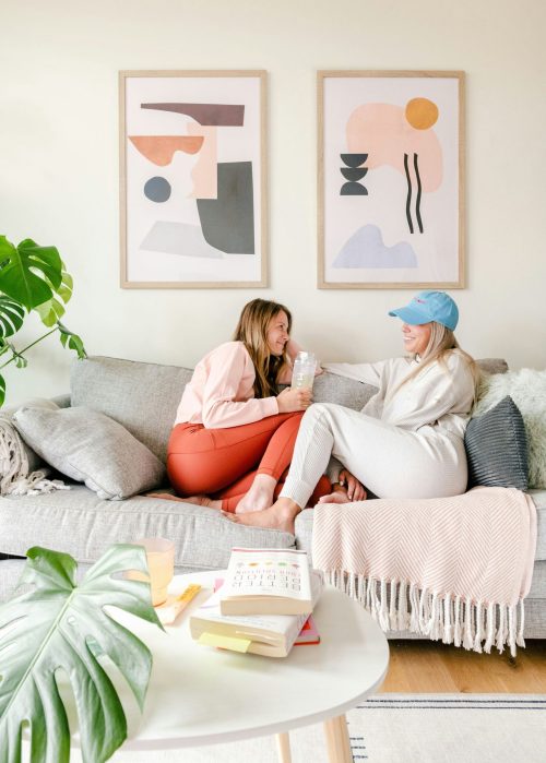 Two friends sitting on the sofa, smiling